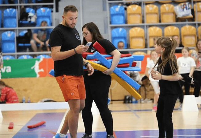 Denny pripravuje farebné prekážky pre Hobby Horse s mladým účastníkom Hobby Horsing v športovej hale