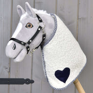 Deka Cube Blue od Hobby Horse LarDen na plyšovom Hobby Horse so sivou tvárou, čiernou uzdečkou a dekou s modrým akcentom, nasadenom na drevenej tyči, na drevenom pozadí.