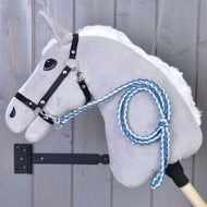 Hobby Horse - pletené vodidlo Double Blue od Hobby Horse LarDen na sivom plyšovom koni s čiernou uzdečkou a modrým ručne pleteným vodidlom s prémiovou karabínou, vystavené pred drevenou stenou.