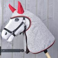 Sivý Hobby Horse s čiernou ohlávkou v melírovanej sivej pláštenke s červenými ušami cez hlavu a krk