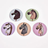 Set Stickers New od Hobby Horse LarDen obsahuje päť nálepiek, každú s jedinečnou ilustráciou hlavy Hobby Horse na farebnom pozadí (modrom, zelenom, fialovom, červenom, ružovom) – perfektná voľba pre fanúšikov alebo ako výrazné dekorácie.