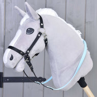 Opraty pogumované Light blue od Hobby Horse LarDen na sivom plyšovom Hobby Horse s bielou hrivou, pripevnenom k drevenej tyči, pred sivou drevenou stenou.