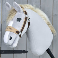 Hobby Horse LarDen Ohlávka s barančekom LarDen Brown so svetlosivým plyšom, krémovou hrivou, béžovohnedou ohlávkou s mäkkým fleecovým nánosníkom, vyšívanými očami a priateľským výrazom na drevenom pozadí.