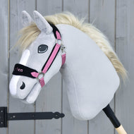 Plyšový šedý Hobby Horse LarDen s bílou hřívou a ohlávkou s beránkem LarDen Pink na tyči před dřevěným plotem.