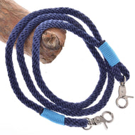 Povrazový set Dark Blue od Hobby Horse LarDen obsahuje stočené tmavomodré vodidlo s kovovými karabínami na oboch koncoch, každú omotanú jasne modrou niťou, a je vystavené na svetlohnedej drevenej vetve – štýlový jazdecký doplnok.