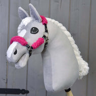 Ručne vyrobený sivý Hobby Horse od Hobby Horse LarDen s bielou hrivou a lysinou, s čiernou ohlávkou z koženky s kompletným ružovým barančekom, na drevenom pozadí.