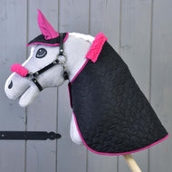 Set Thermo Pinkie (čabraka + deka + ohlávka s barančekom) od Hobby Horse LarDen obsahuje sivého Hobby Horse s čiernou dekou s ružovým lemovaním, ladiacou ružovou čabrakou a ohlávkou s barančekom, zobrazeného na drevenom pozadí.