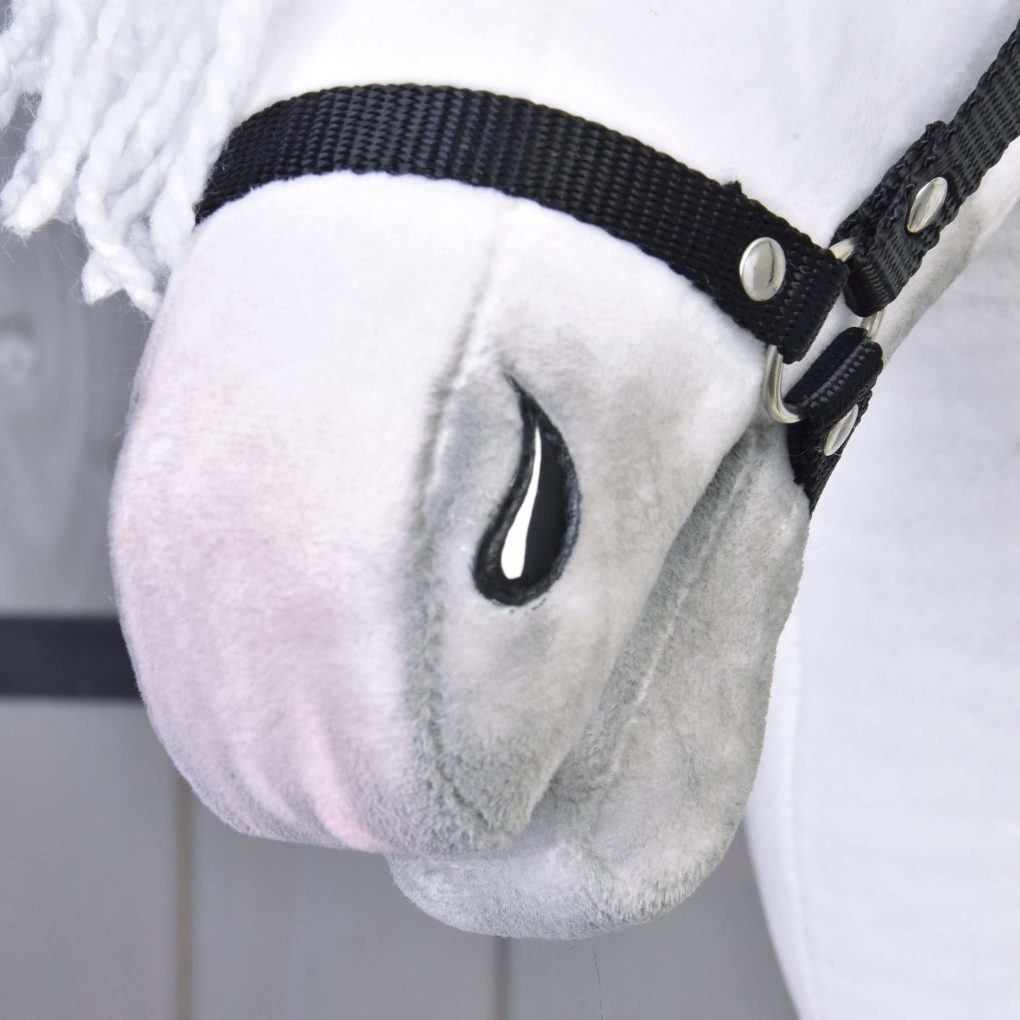 Detail Hobby Horse Elektra s čiernou ohlávkou od Hobby Horse LarDen s plyšovou bielou tvárou, čiernou ohlávkou, vyšívaným čiernym detailom v tvare slzy, jemnou textúrou, bielou priadzovou hrivou a črtami inšpirovanými lipicánskou kobylou.