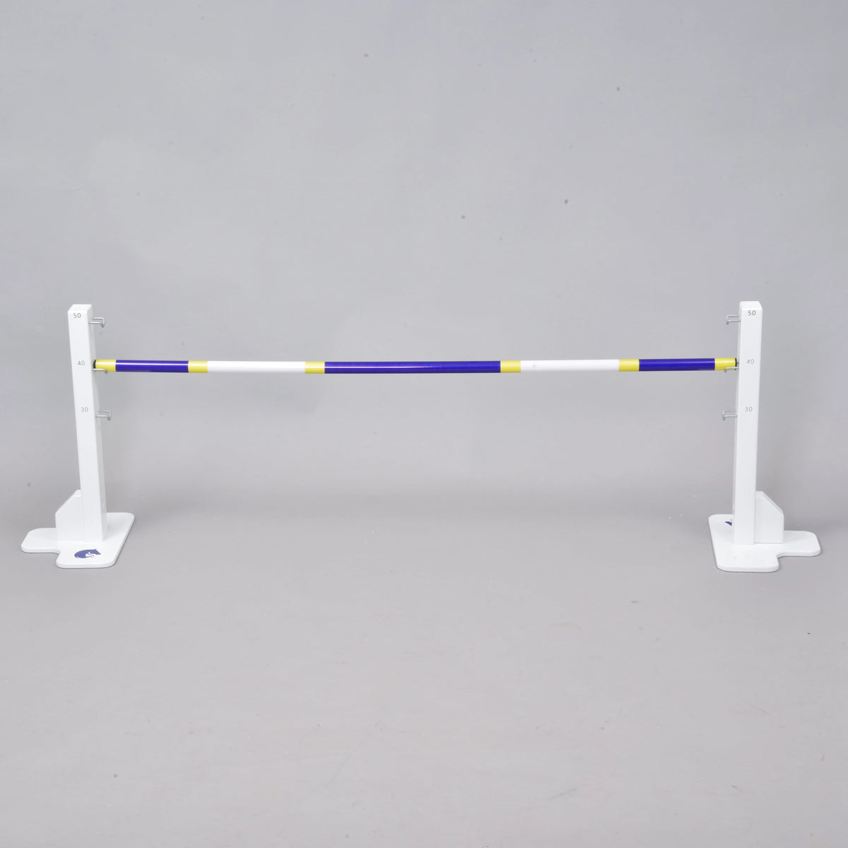 Prekážka kolmák 50 cm od Hobby Horse LarDen je biely nastaviteľný stojan na skok s modrou, žltou a bielou tyčou — ideálna pre Hobby Horsing vnútri aj vonku — zobrazené na jednofarebnom sivom pozadí.