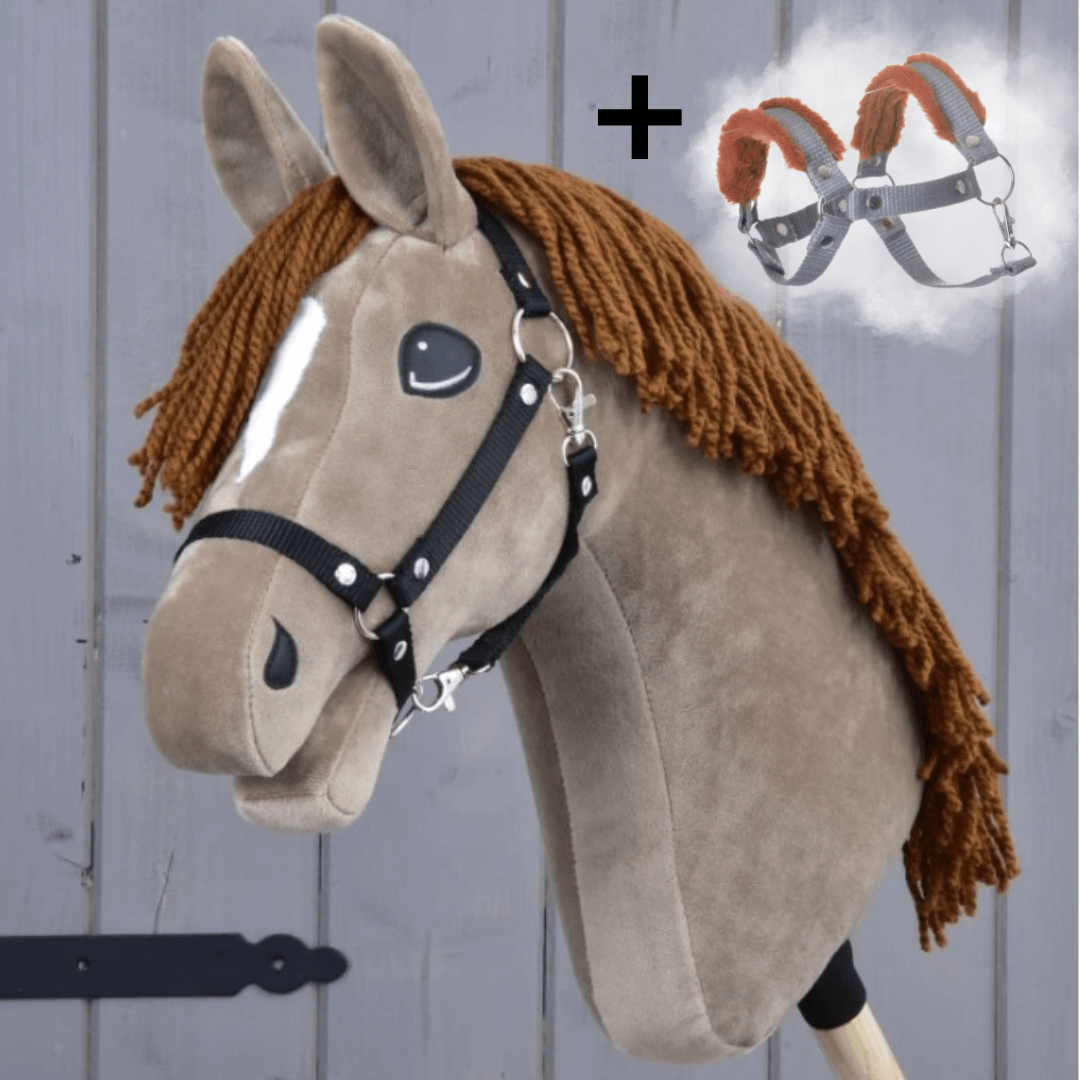 Hobby Horse Oliver s čiernou ohlávkou + ohlávkou s barančekom ZADARMO od Hobby Horse LarDen na drevenom pozadí, s hnedou hrivou, bielym odznakom, čiernou ohlávkou a pridaným obrázkom postroja so symbolom plus.