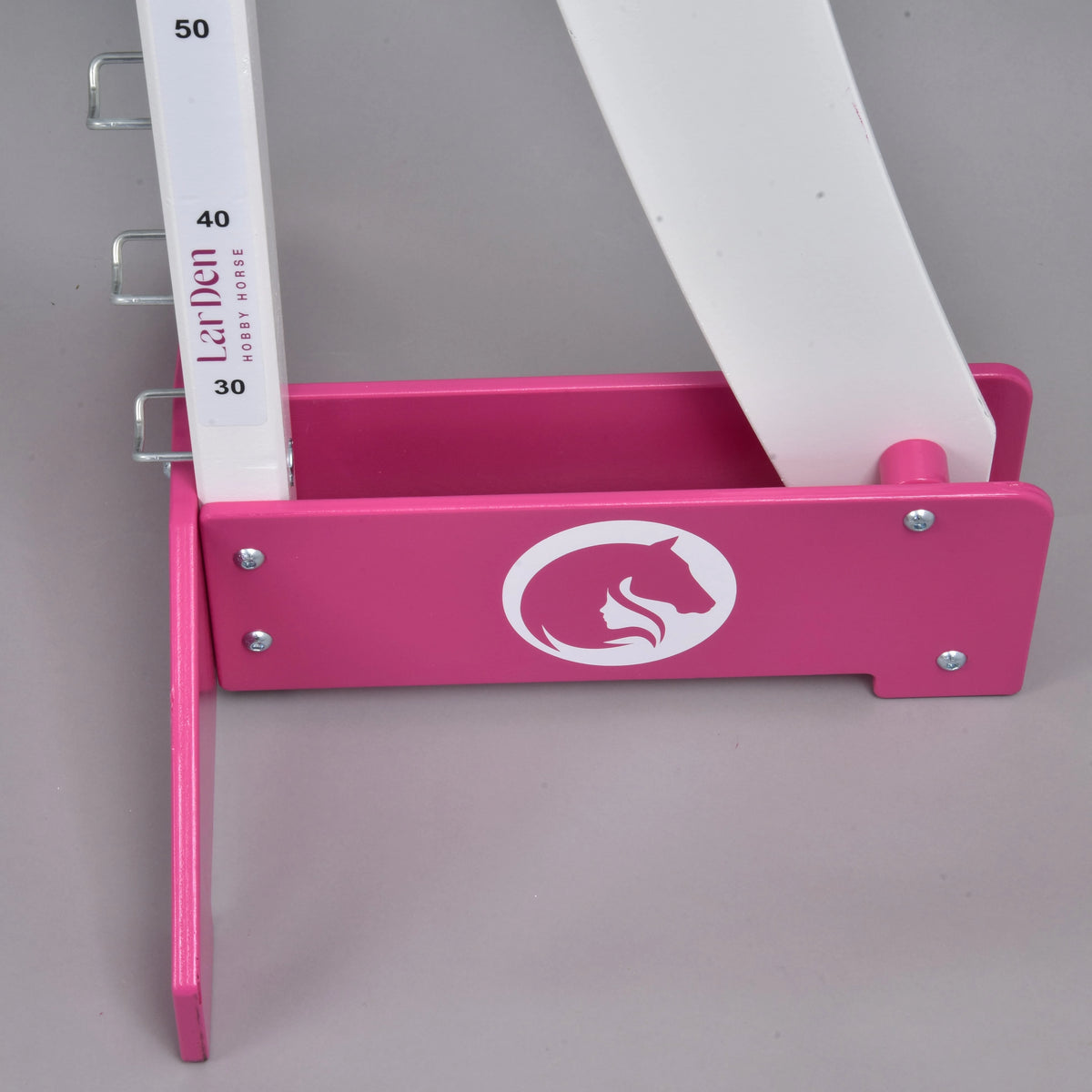 Detail LarDen skoku mohutnosti od Hobby Horse LarDen v ružovej a bielej farbe s výškovými značkami a logom konskej hlavy na základni – ideálny pre Hobby Horse puissance podujatia.