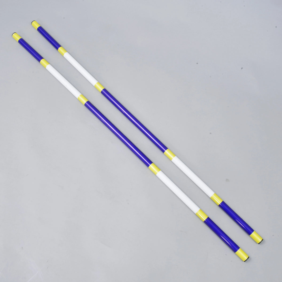 Bariérka modro-biela, 2 ks od Hobby Horse LarDen, dve ľahké tyče z poťahovaného PVC s priemerom 32 mm, ležiace rovnobežne na svetlosivom povrchu.
