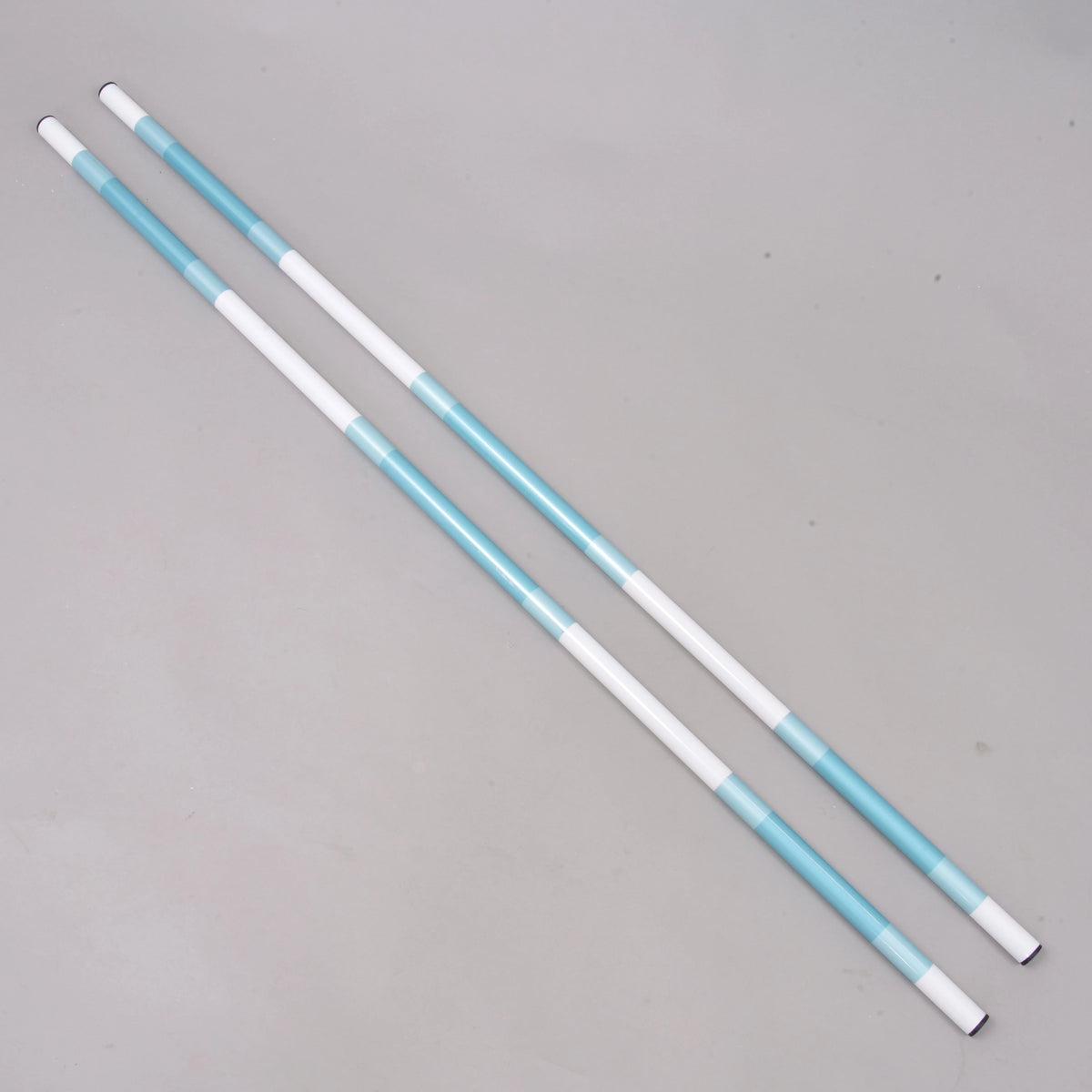 Bariérka tyrkysovo-biela, 2 ks od Hobby Horse LarDen, vyrobená z poťahovaného PVC s priemerom 32 mm so striedajúcimi sa bielymi a tyrkysovými časťami, leží vedľa seba na jednofarebnom svetlosivom povrchu.