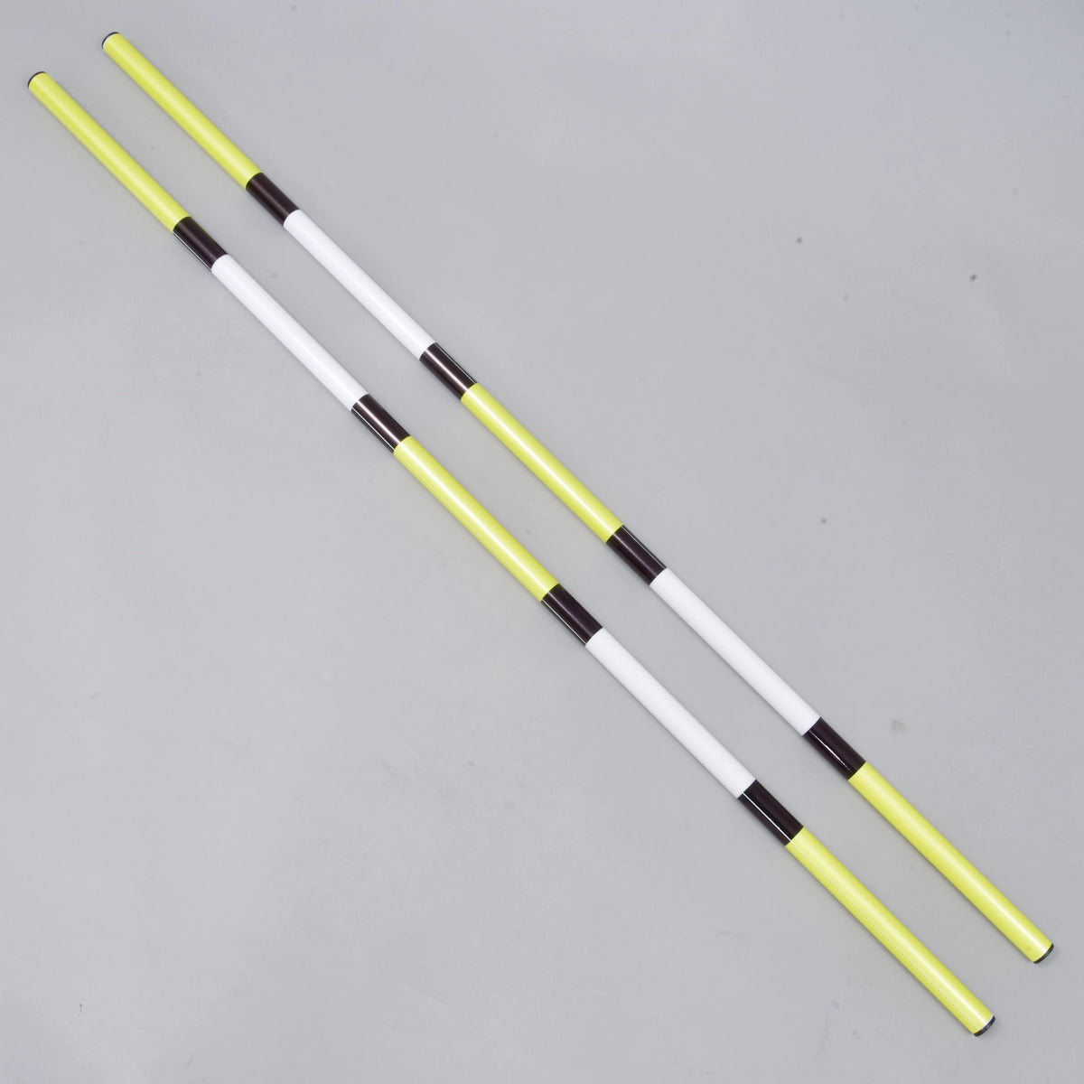 Bariérka žlto-čierna, 2 ks od Hobby Horse LarDen obsahuje dve ľahké tyče z poťahovaného PVC s priemerom 32 mm so striedajúcimi sa žltými, bielymi a čiernymi časťami, zobrazené rovnobežne na svetlosivom povrchu.
