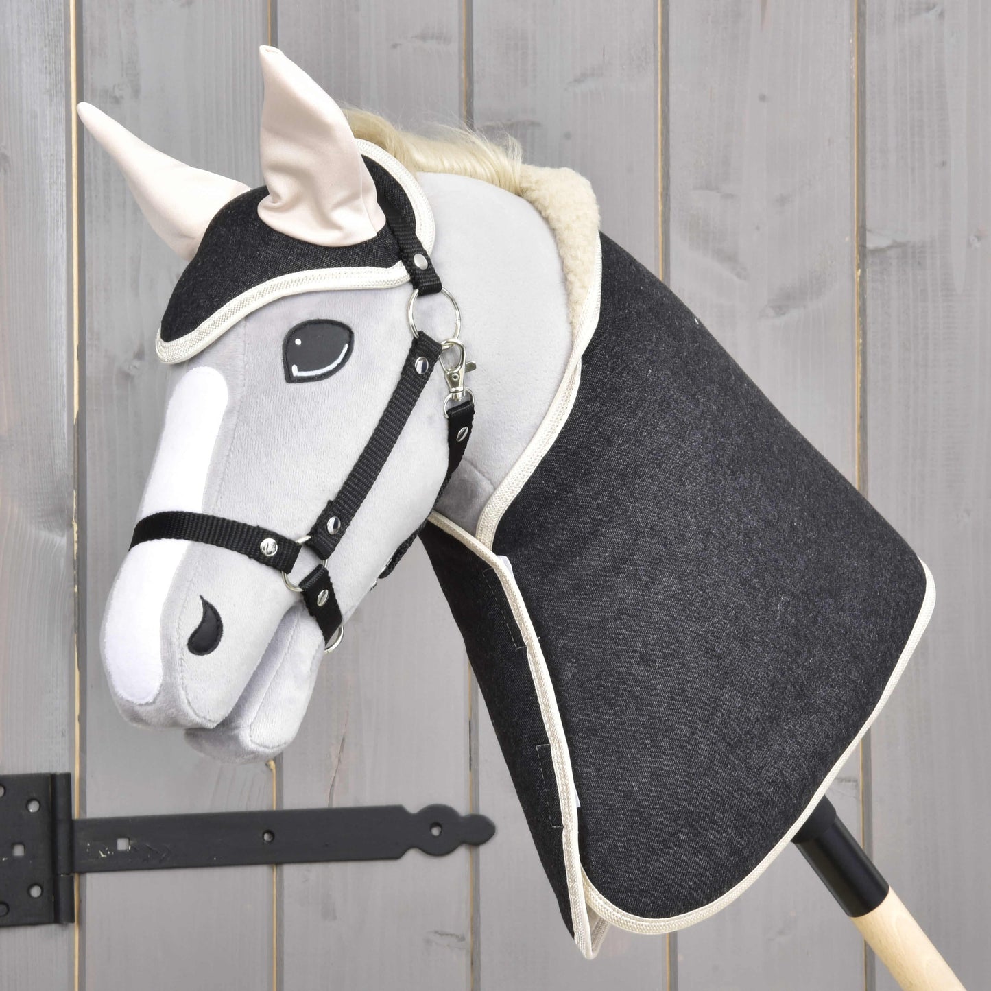 Set Blue Denim od Hobby Horse LarDen s ručne vyrábaným Hobby Horse s hlavou z modrého denimu a drevenou tyčou vytvára pôvabnú dekoráciu, ktorá vyniká pred pozadím zo svetlých drevených panelov.