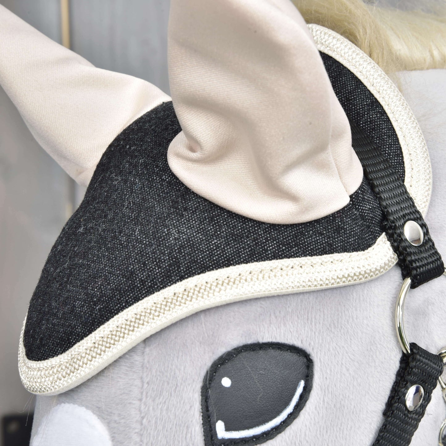 Detailný záber na hlavu Set Blue Denim od Hobby Horse LarDen ukazuje čiernu uzdečku s bielym lemovaním, krémové uši, hladký sivý povrch a vyšívané oko – roztomilá dekorácia pre milovníkov koní.