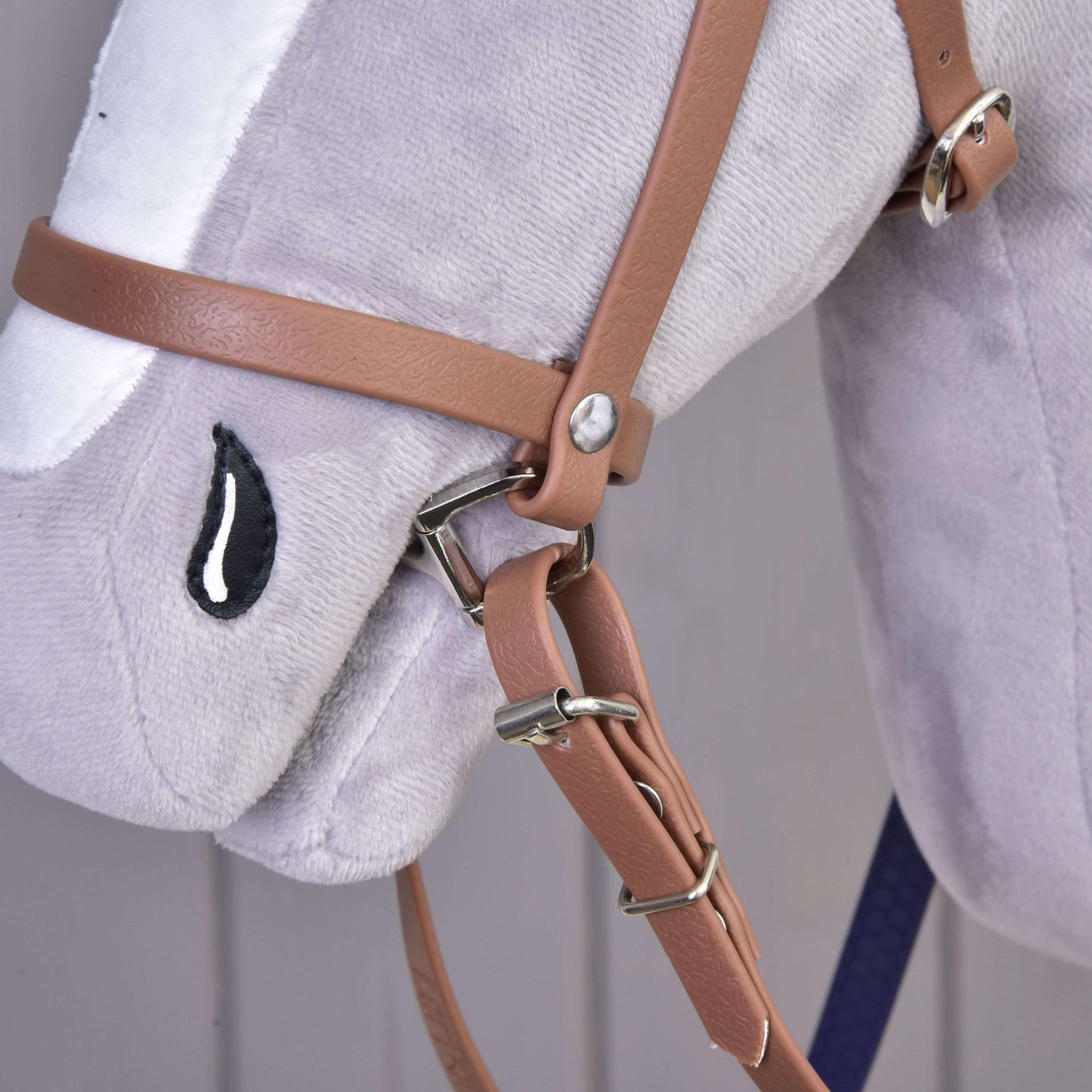Detail plyšovej konskej hlavy Hobby Horse LarDen s Kompletná uzdečka s nánosníkom Brown Purple a vyšívaným čierno-bielym okom v tvare kvapky.
