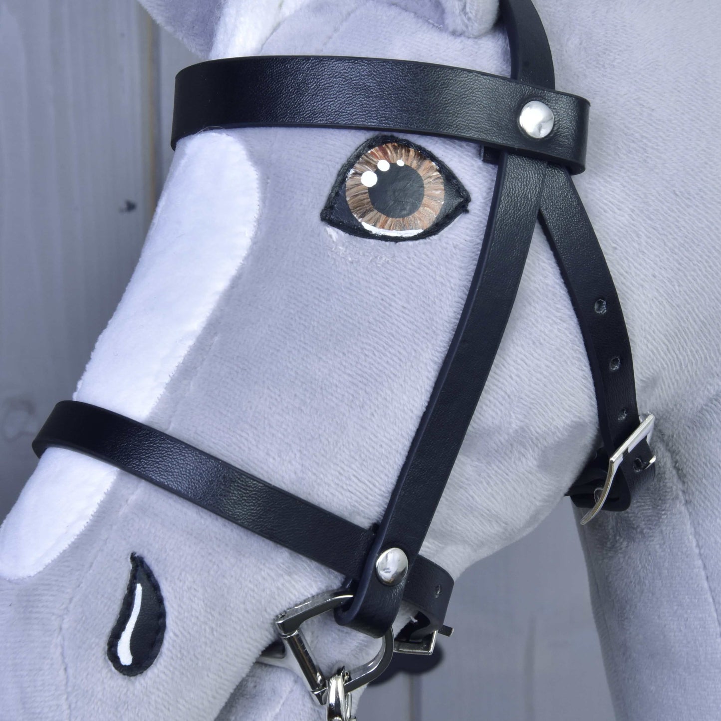 Detail Hobby Horse LarDen Set Basic, sivo-bieleho plyšového koňa s prepracovaným prešívaním, realisticky vyšitým okom a nozdrou a čiernou koženou uzdečkou s opratami.