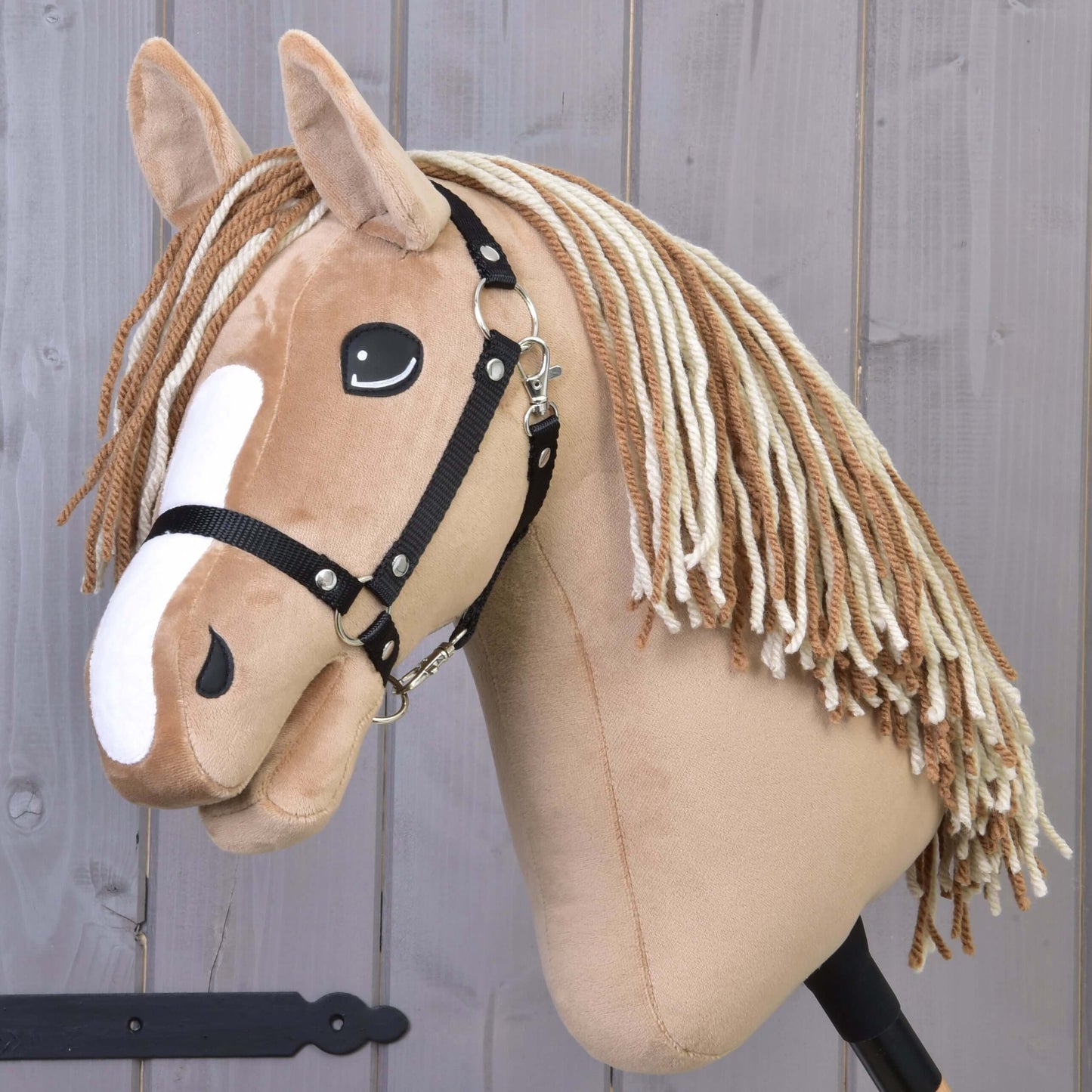 Hobby Horse Bren s čiernou ohlávkou od Hobby Horse LarDen, so svetlohnedým telom, bielymi znakmi na hlave a dlhou priadzovou hrivou, na drevenom pozadí.
