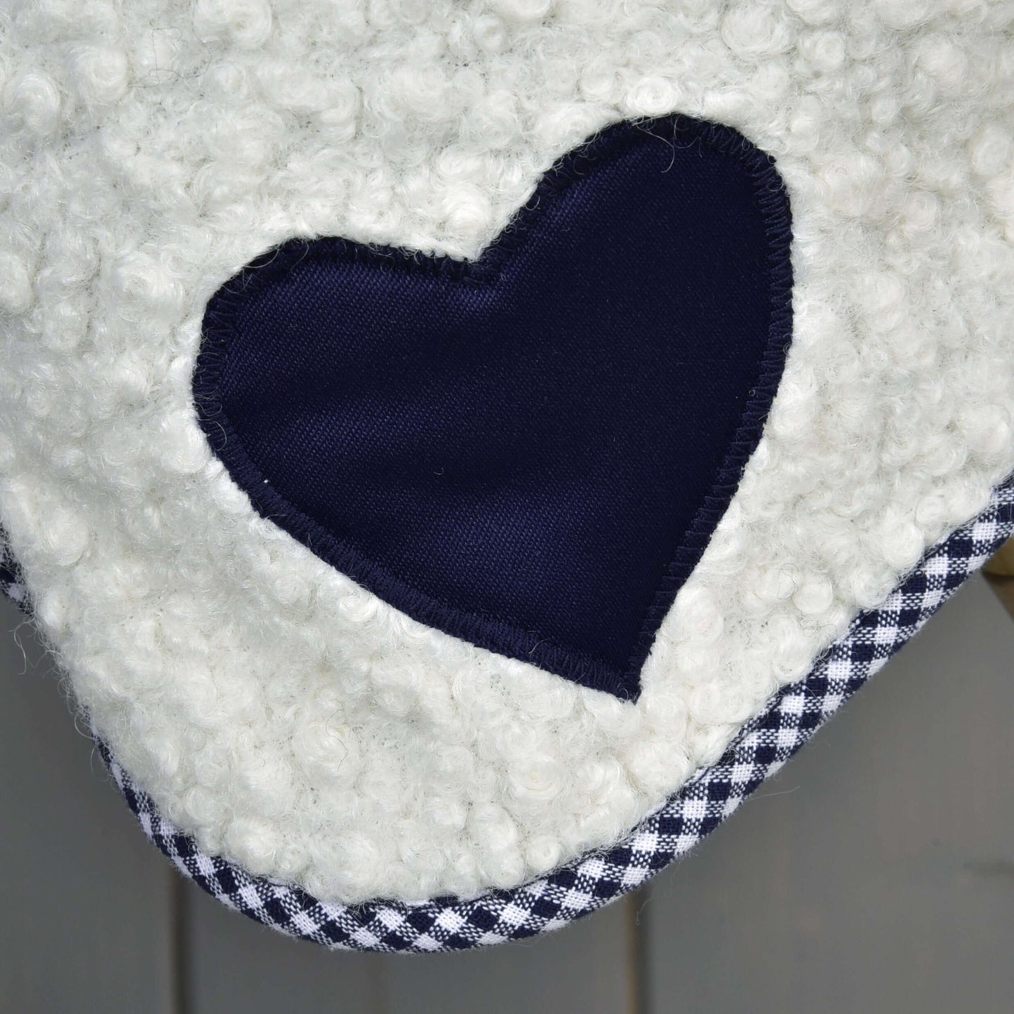Detail Deky Cube Blue od Hobby Horse LarDen – biela textúrovaná látka s tmavomodrou nášivkou v tvare srdca a čiernobielym károvaným lemom, ideálna ako deka pre Hobby Horse.