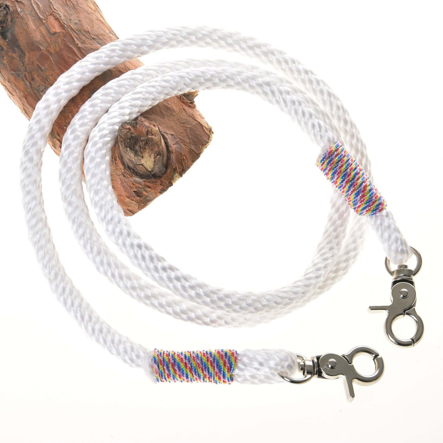 Opraty biele od Hobby Horse LarDen s kovovými karabínami na oboch koncoch a dúhovo farebnou niťou pri každej karabíne, stočené na dreve na bielom pozadí, pripomínajúce kvalitné opraty k bezzubadlovej uzdečke.