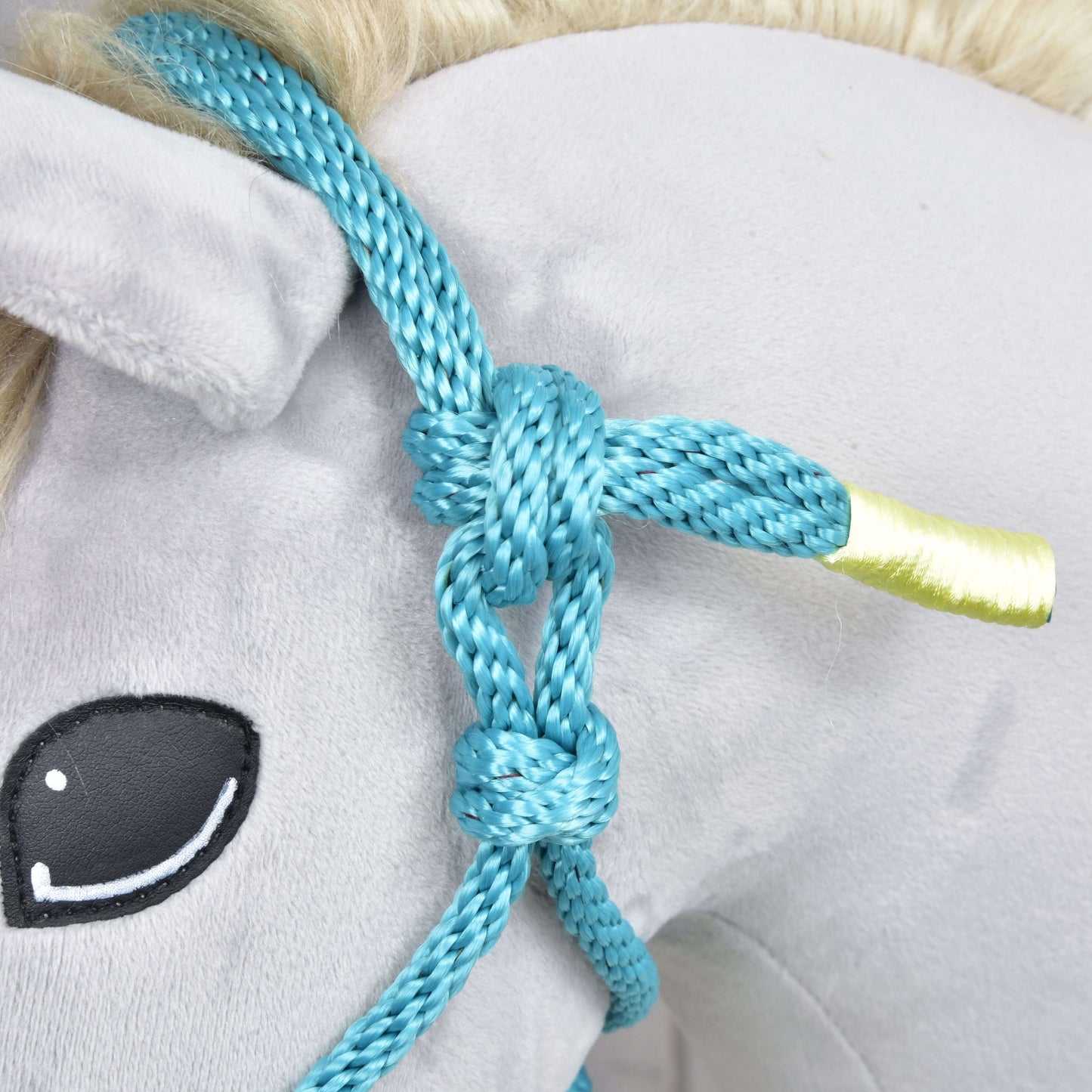 Detail Parelka Tyrkys od Hobby Horse LarDen na hlave plyšového Hobby Horse so žlto zakončeným uchom, čiernym vyšívaným okom a svetlou hrivou – roztomilý doplnok pre každého nadšenca do Hobby Horse.