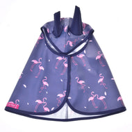 Pláštenka Flamingo od Hobby Horse LarDen je modrá pláštenka pre maznáčikov s ružovými plameniakmi a dvoma klopami kapucne pripomínajúcimi uši, ideálna do každého počasia. Je zobrazená naplocho s otvorenou prednou časťou a malým štítkom Laz Dera v ľavom dolnom rohu.