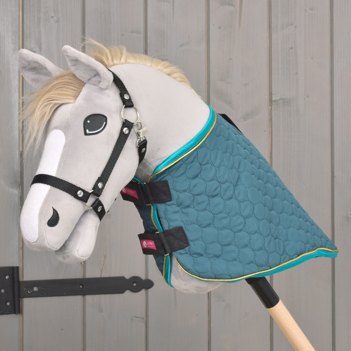 Bočný pohľad na zelenú prešívanú Hobby Horse deku s tyrkysovým lemom a odnímateľným nákrčníkom