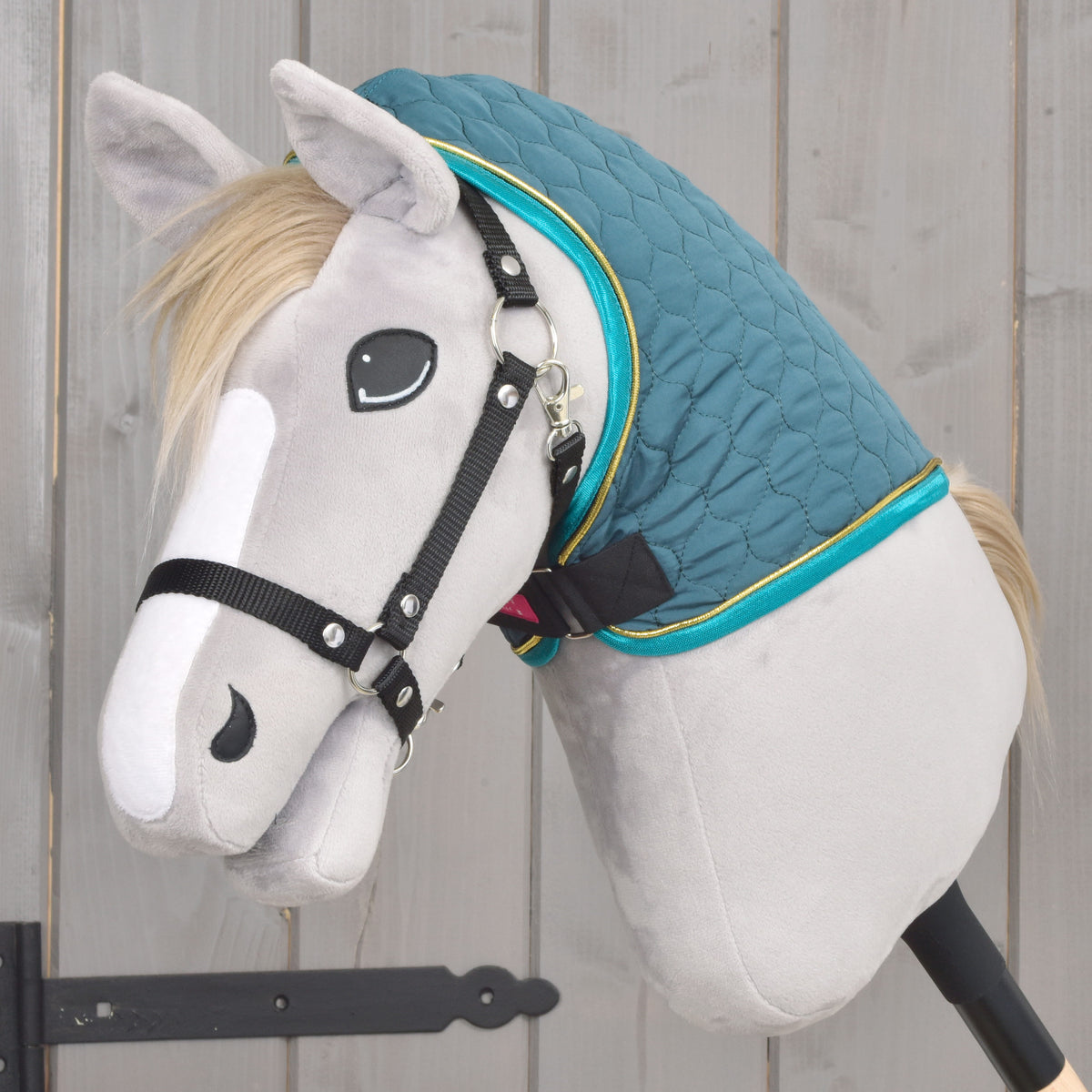 Zelená prešívaná Hobby Horse deka s odnímateľným nákrčníkom z bočného pohľadu na sivom Hobby Horse