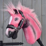 Limitovaná edícia Hobby Horse LarDen Pinkie s trblietavou ohlávkou, s huňatou hrivou a bielou škvrnou na tvári, umiestnená pred sivými drevenými panelmi.