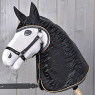 Realistický Hobby Horse s bielou hlavou, čiernou hrivou a čiernou uzdečkou stojí na pozadí svetlých drevených panelov a má na sebe Hobby Horse LarDen Pláštenka Luxury.