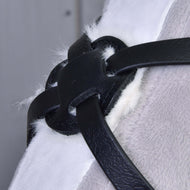 Detail černých kožených řemínků a zapínání nánosníku z koženky z produktu Mexický nánosník černý podšitý od Hobby Horse LarDen, které drží jemnou chlupatou bílou a šedou látku pohromadě.