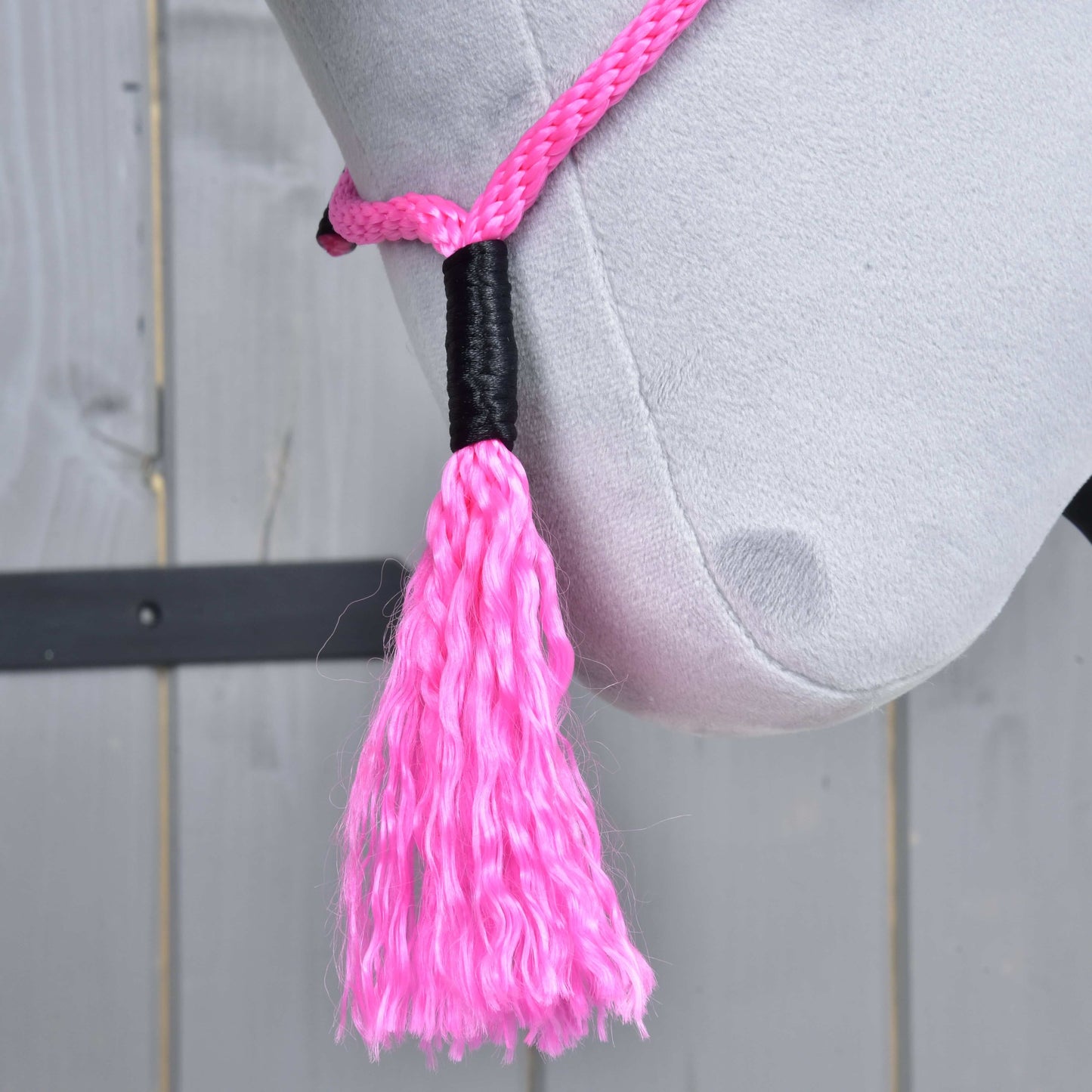Detail Hobby Horse LarDen „Nákrčník Pink Festive“ – hlava svetlosivého plyšového koňa s ružovou lanovou ohlávkou a strapcom na drevenom pozadí. Ideálne pre fanúšikov Hobby Horse cordea alebo jazdenia bez uzdečky.