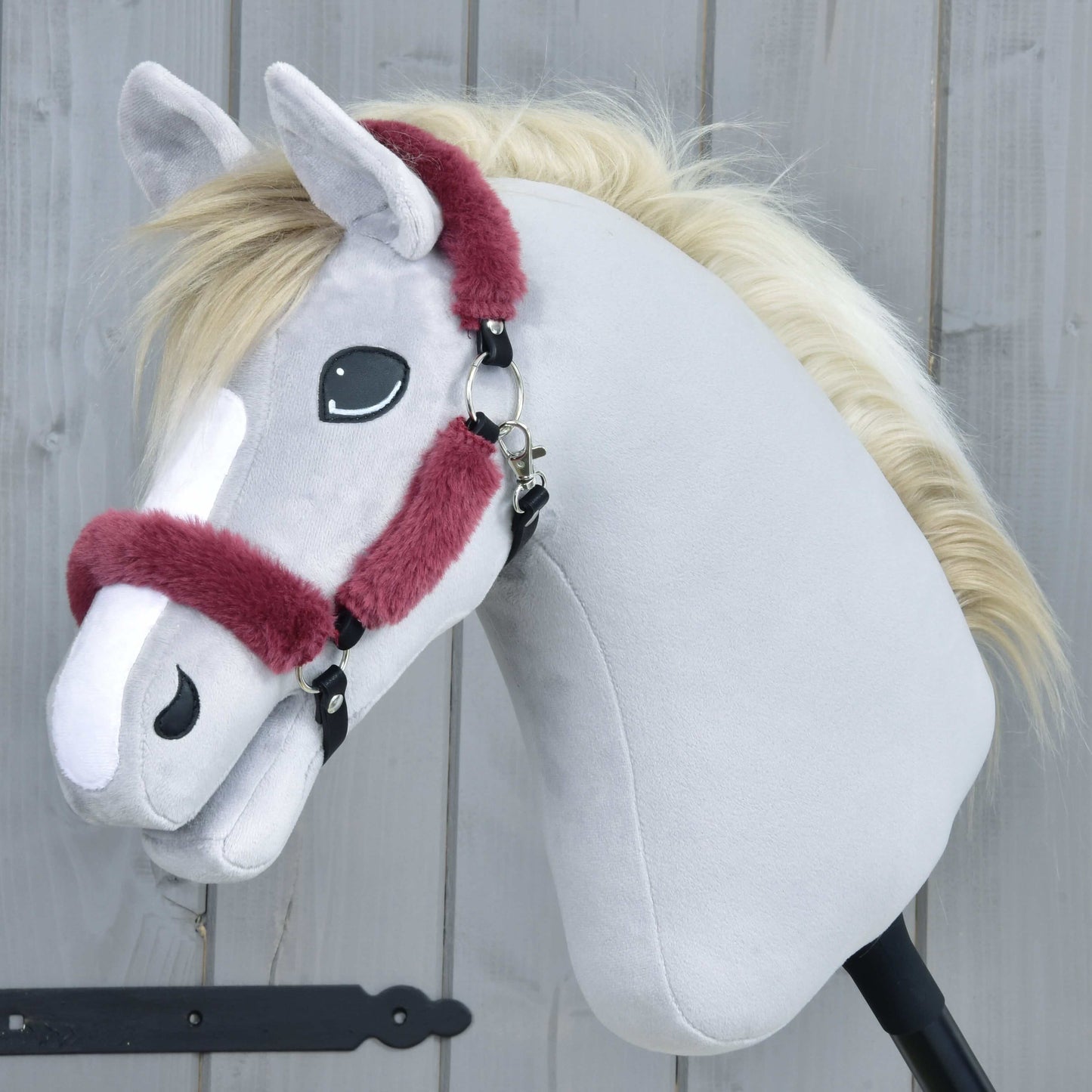 Hobby Horse LarDen Ohlávka s barančekom Teddy Maroon na svetlosivom plyšovom koni s krémovou hrivou a vínovou ohlávkou, zobrazená vo vzpriamenej polohe pred drevenou stenou.