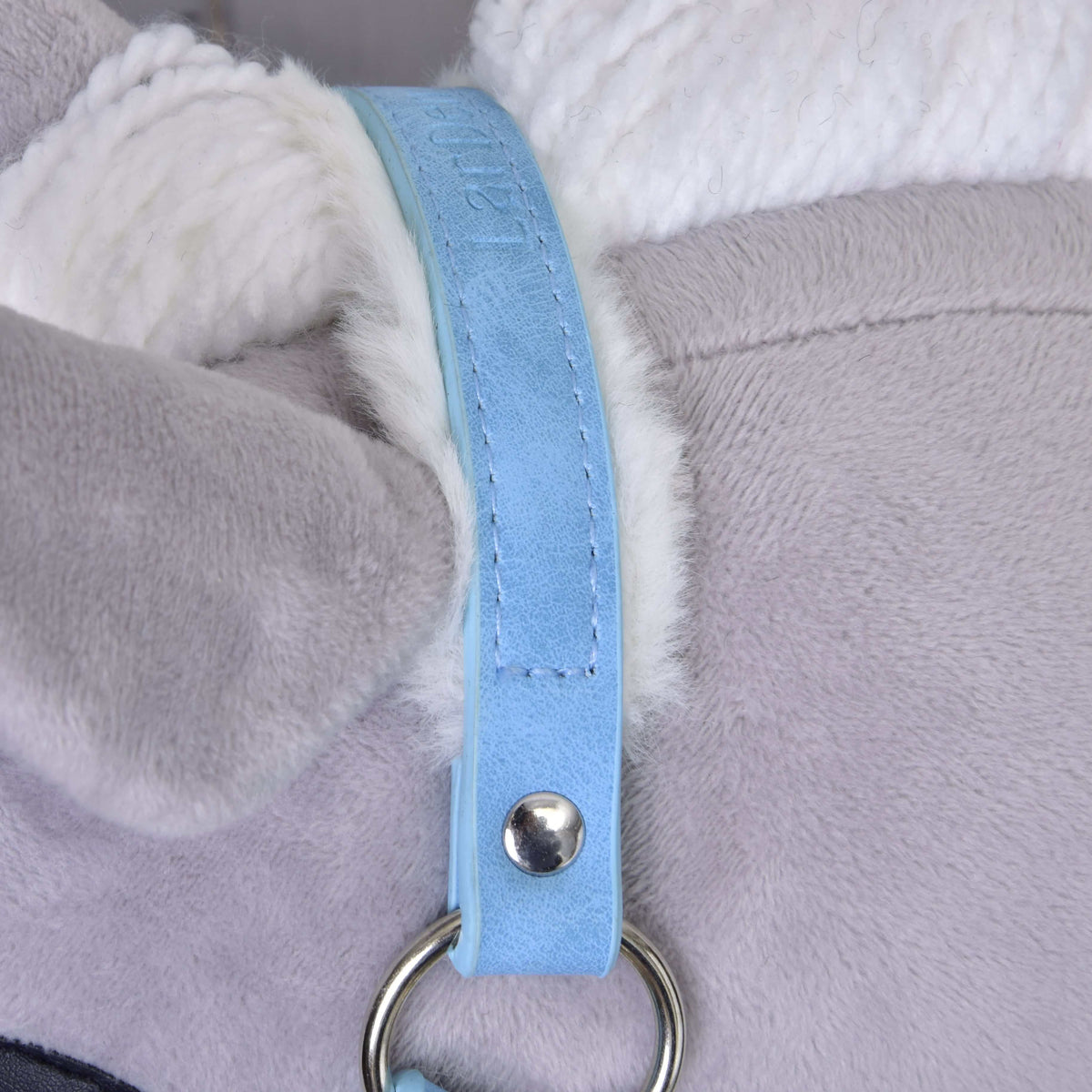 Detail ohlávky Hobby Horse LarDen Ohlávka s barančekom z koženky Pastell Blue so svetlosivým plyšom, bielymi akcentmi a pastelovo modrým pásikom pripevneným strieborným krúžkom a nitom.