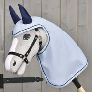 Pláštenka Luméa od Hobby Horse LarDen na plyšovom sivom Hobby Horse s čiernou uzdečkou, modrou pláštenkou a tmavomodrými krytmi uší, zobrazená na svetlom drevenom pozadí.