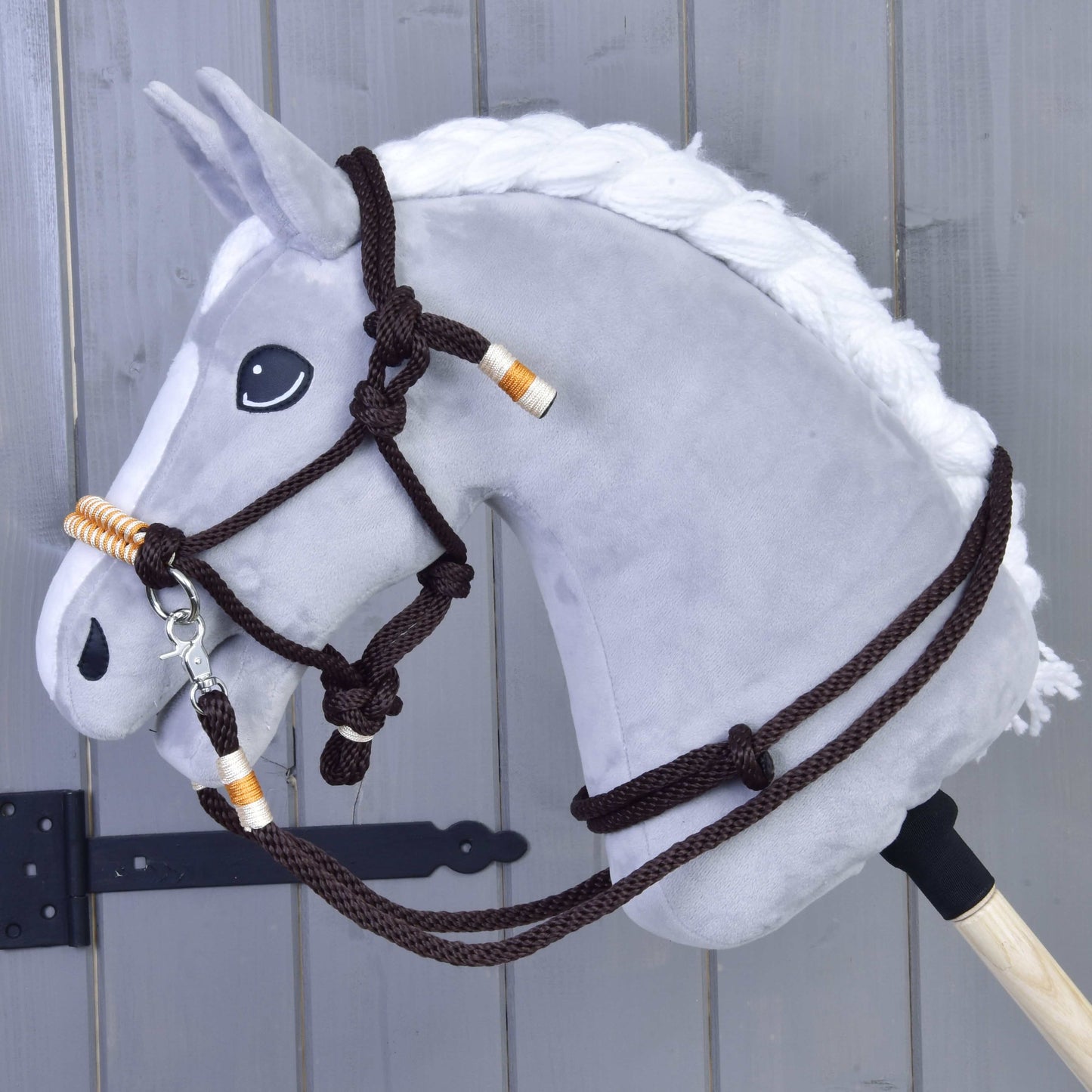 Povrazový set Orange od Hobby Horse LarDen je zobrazený pred dreveným plotom, s oranžovým povrazovým setom bezpečne pripevneným k pevnej drevenej tyči.