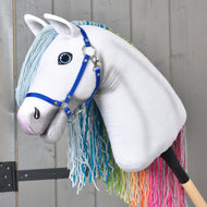 Rozprávkový Hobby Horse Rainbow New od Hobby Horse LarDen s modrými opratami, svetlomodrou priadzovou hrivou a dúhovou hrivou na chvoste na sivom drevenom pozadí