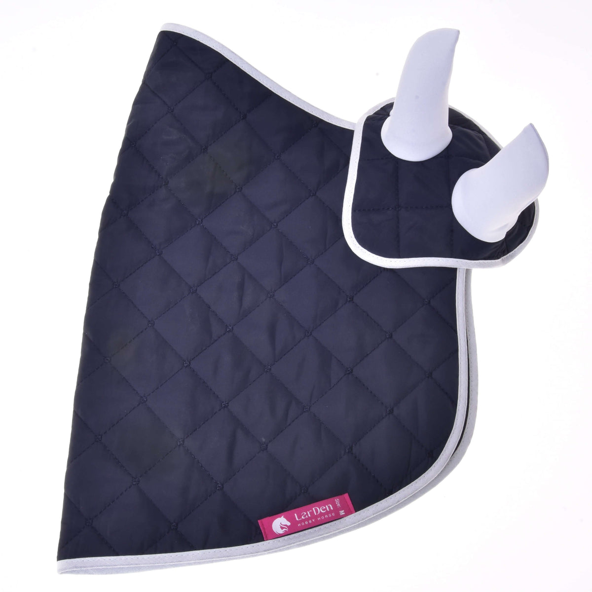 Set Monte od Hobby Horse LarDen je tmavomodrá prešívaná deka so svetlosivým lemovaním a dvoma bielymi polstrovanými krytmi uší, tvoriaca štýlovú sadu čabraky na uši. Ružový štítok s logom koňa dodáva vzhľadu tvojho koňa ďalšiu dekoráciu.