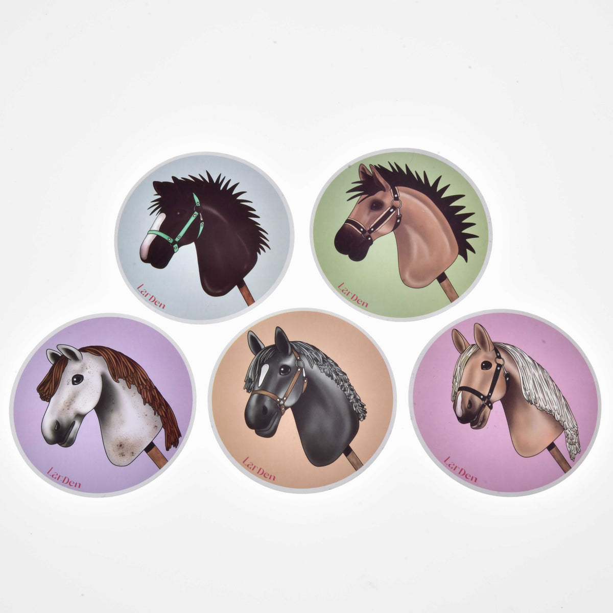Päť okrúhlych nálepiek Set Stickers New od Hobby Horse LarDen, každá s ilustráciou hlavy Hobby Horse, usporiadaných do kruhu na pastelovo modrom, zelenom, fialovom, béžovom a ružovom pozadí.