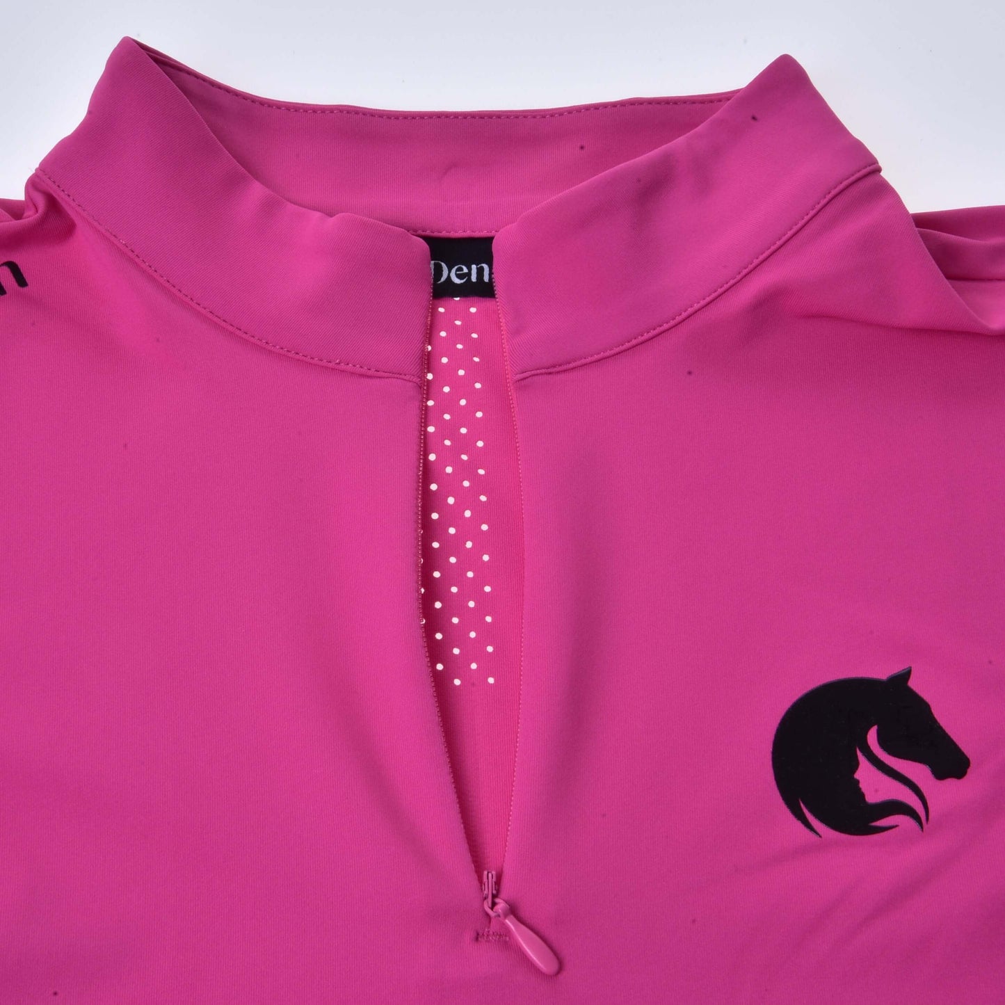Športové tričko LarDen Pink od Hobby Horse LarDen, žiarivo ružové športové tričko s golierom, krátkymi rukávmi, predným polovičným zipsom lemovaným bielymi bodkami a čiernym logom konskej hlavy na hrudi.