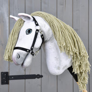 Hobby Horse Victory s černou ohlávkou - velikost M od Hobby Horse LarDen, s bílou plyšovou hlavou, blond hřívou z příze, černou ohlávkou a malovaným modrým okem, na dřevěné tyči, před šedou dřevěnou stěnou.