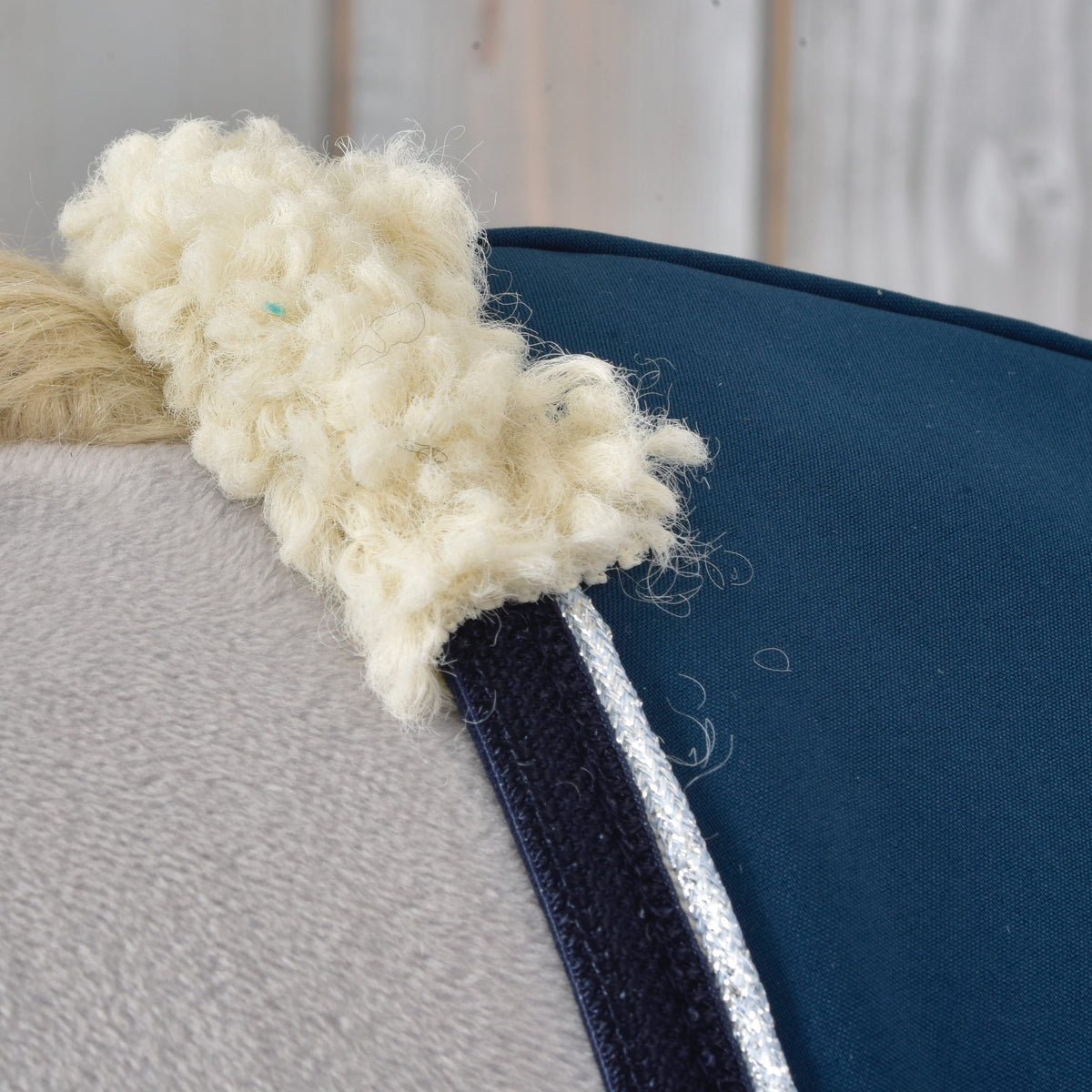 Close view of the cream neck lining and silver-edged blue stable blanket on a Hobby Horse