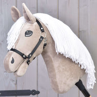 Hobby Horse Blondie s černou ohlávkou od Hobby Horse LarDen má béžový obličej, bílou přízovou hřívu a černou ohlávku na dřevěné tyči, vystavený před světle šedým dřevěným pozadím.
