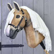 Hobby Horse Connie s černou ohlávkou od Hobby Horse LarDen s realistickým béžovo-bílým designem, dlouhou bílou přízovou hřívou, nasazený na tyči před šedou dřevěnou stěnou.