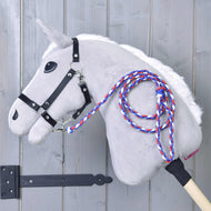 Hobby Horse LarDen Hobby Horse - vodítko Flag CZ, se šedým tělem, bílou hřívou, černou uzdečkou a pleteným červeným, bílým a modrým vodítkem na dřevěné tyči, zobrazený opřený o světle šedou dřevěnou stěnu.