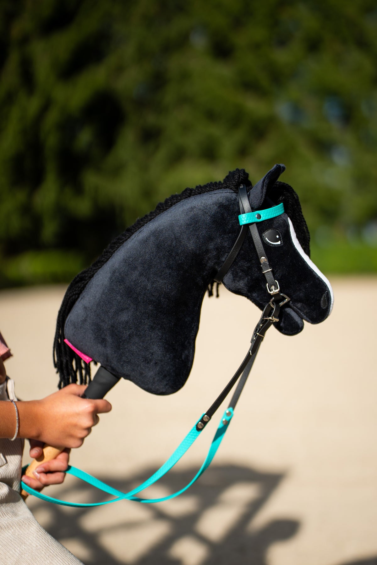 Čierny plyšový Hobby Horse s tyrkysovou a čiernou uzdečkou z koženky a oťažami vonku