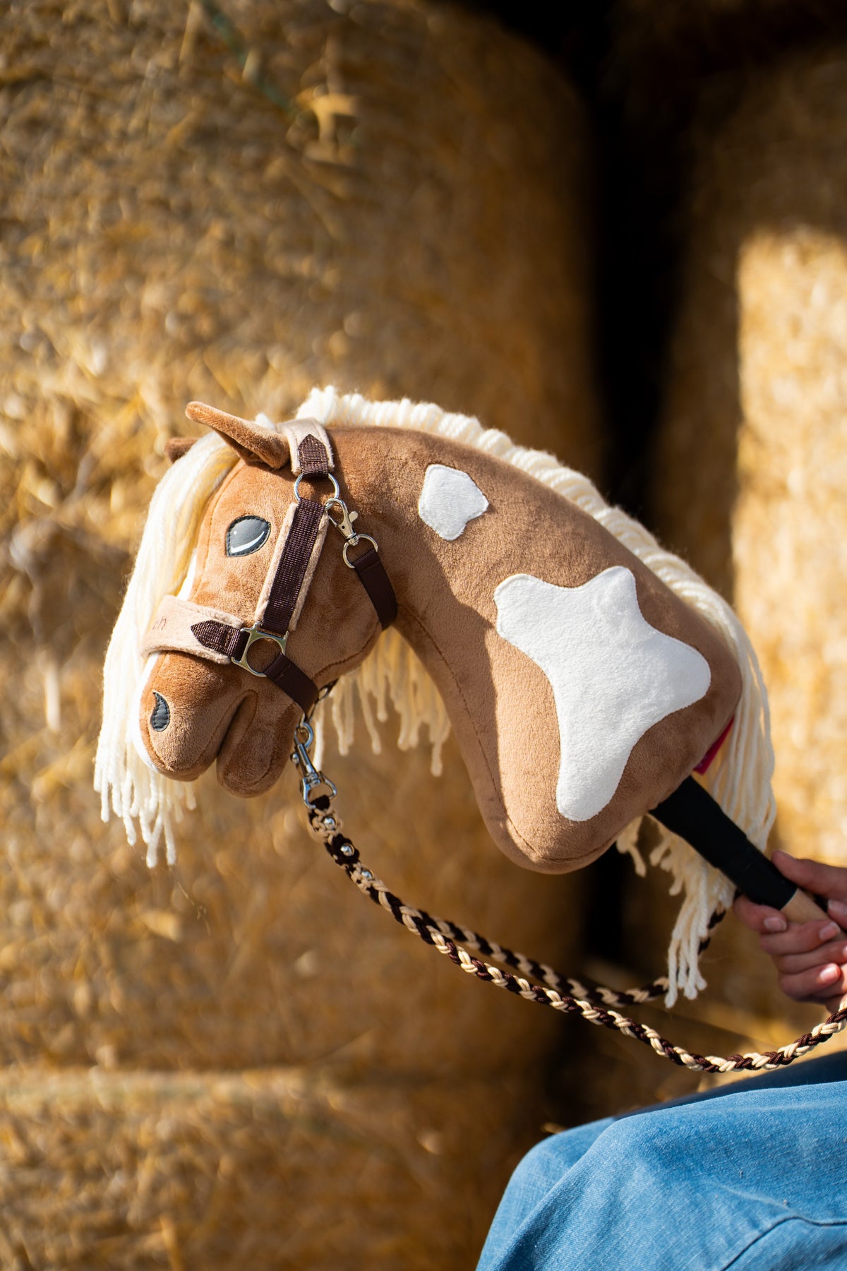 Vodítko Hobby Horse Bloom Brown pripevnené k hnedému Hobby Horse pri balíkoch slamy