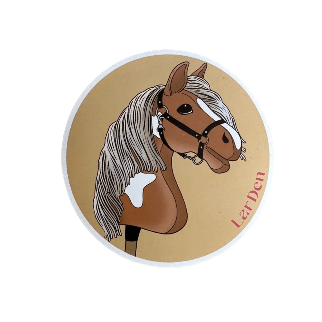 Ilustrácia hnedobieleho Hobby Horse s bielou hrivou, čiernou uzdečkou a neutrálnym pozadím. Na pravom okraji je ružovo napísané „LarDen“. Set Stickers 5 od Hobby Horse LarDen – ideálne pre fanúšikov Hobby Horse!
