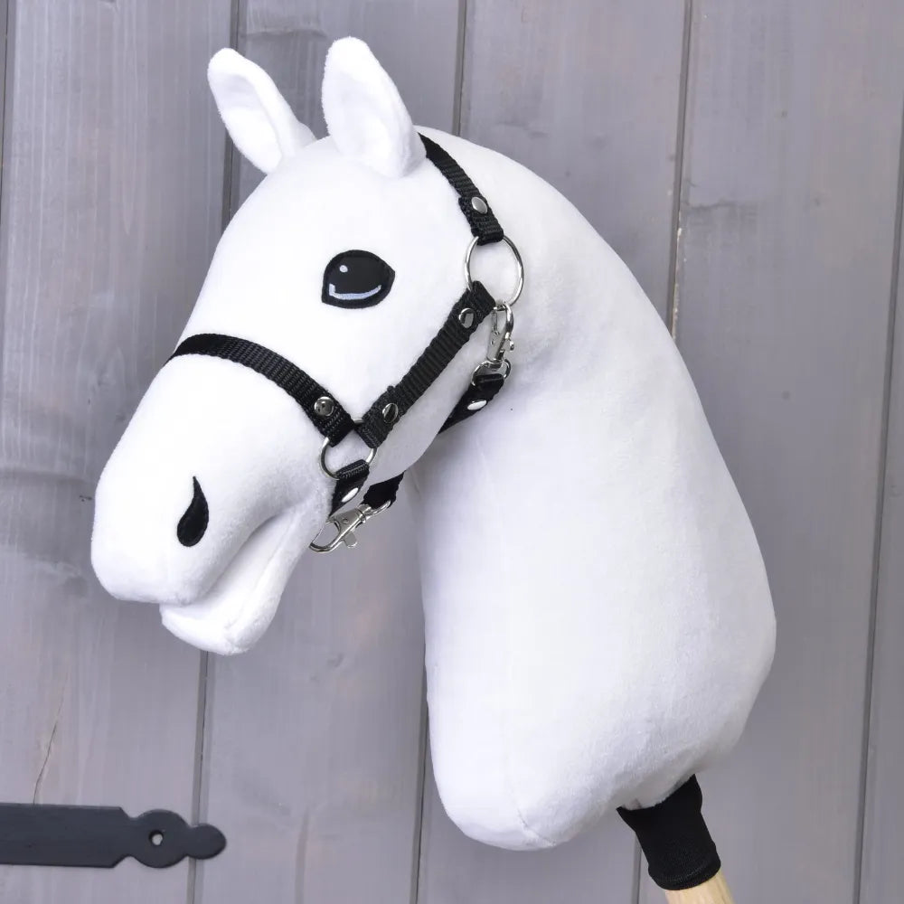 The Build your horse by related_to_12441055625556 features a white hobby horse with a tricolor faux fur mane and black bridle, mounted on a wooden stick against a light gray wooden background.